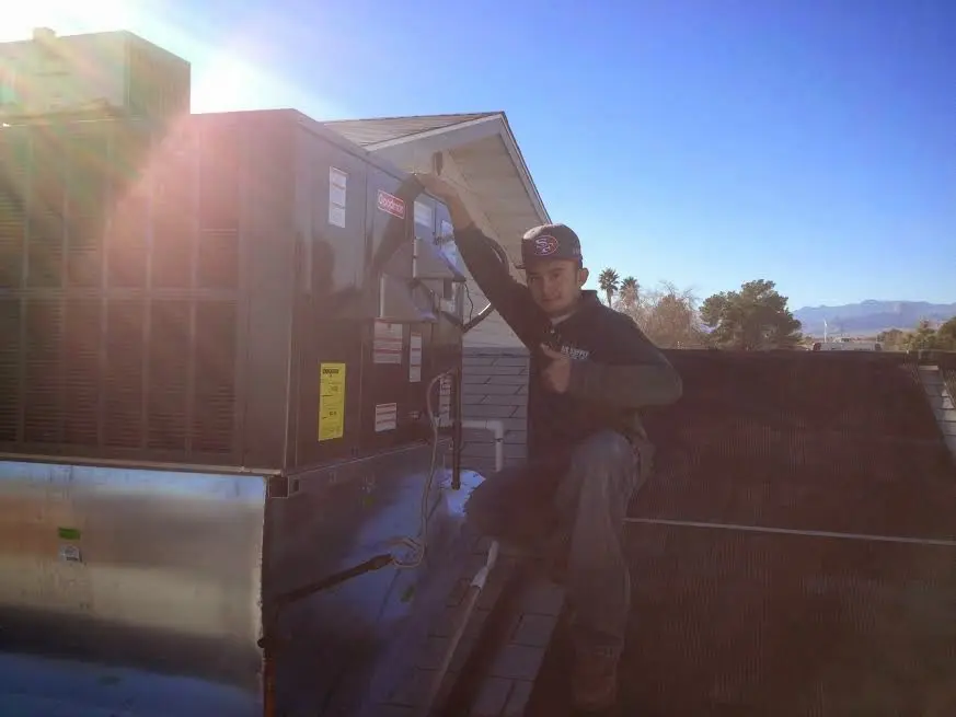 HVAC technician performing Boiler Repair on a rooftop unit in Dunn Loring